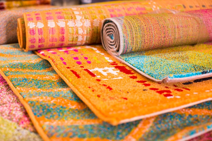 Various colourful wool rugs for sale at store