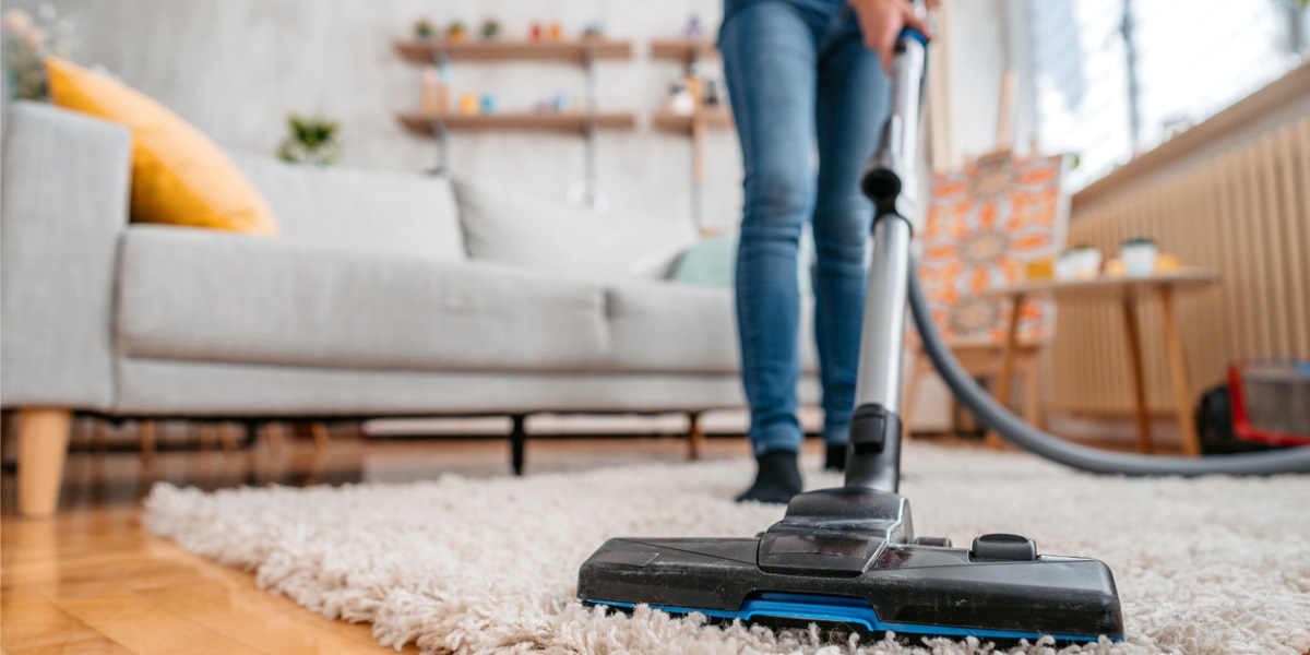 Various tools used for rug cleaning including a vacuum, brush, and cleaning solution